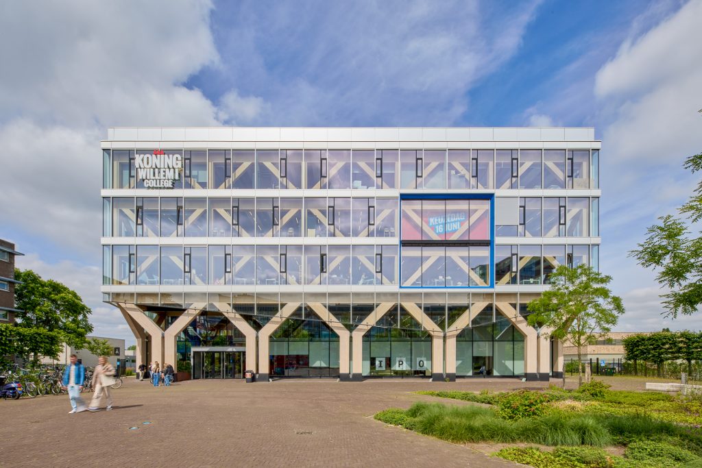 Koning Willem I College met zonwerend glas en banner “Hier komt nieuwe kunst”