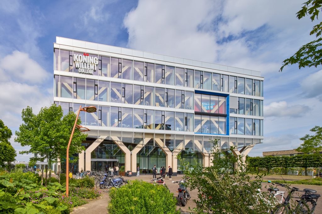 Koning Willem I College met zonwerend glas, fietsen en groene omgeving
