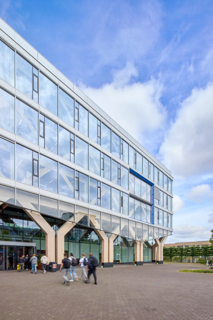 Modern gebouw met zonwerend glas en groene beplanting bij Koning Willem I College