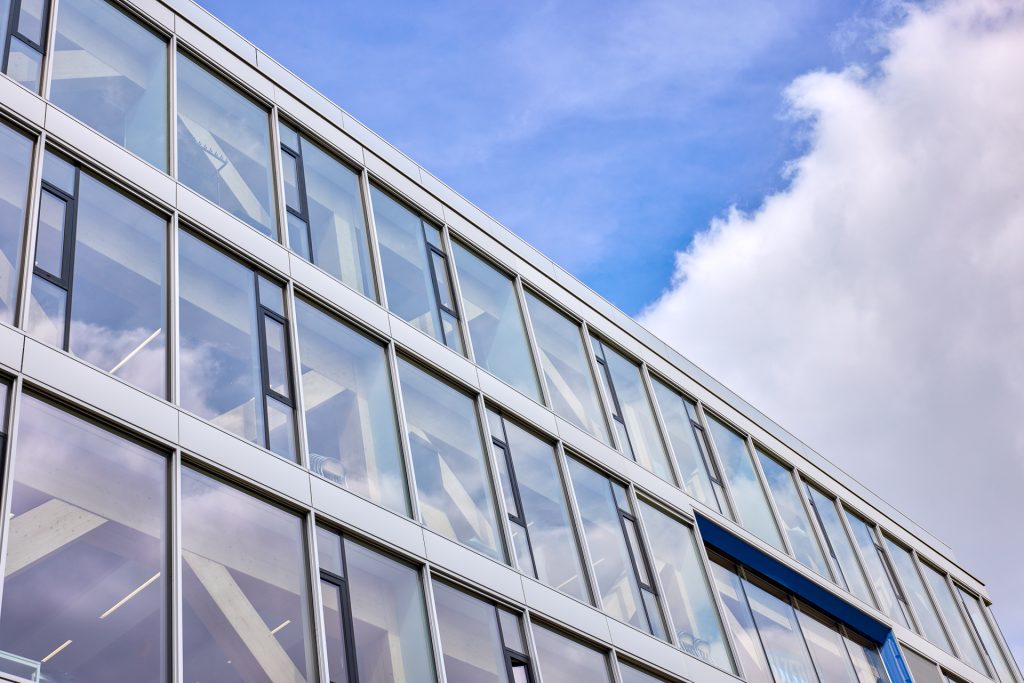 Gebouw met zonwerend glas en witte gevelpanelen bij Koning Willem I College