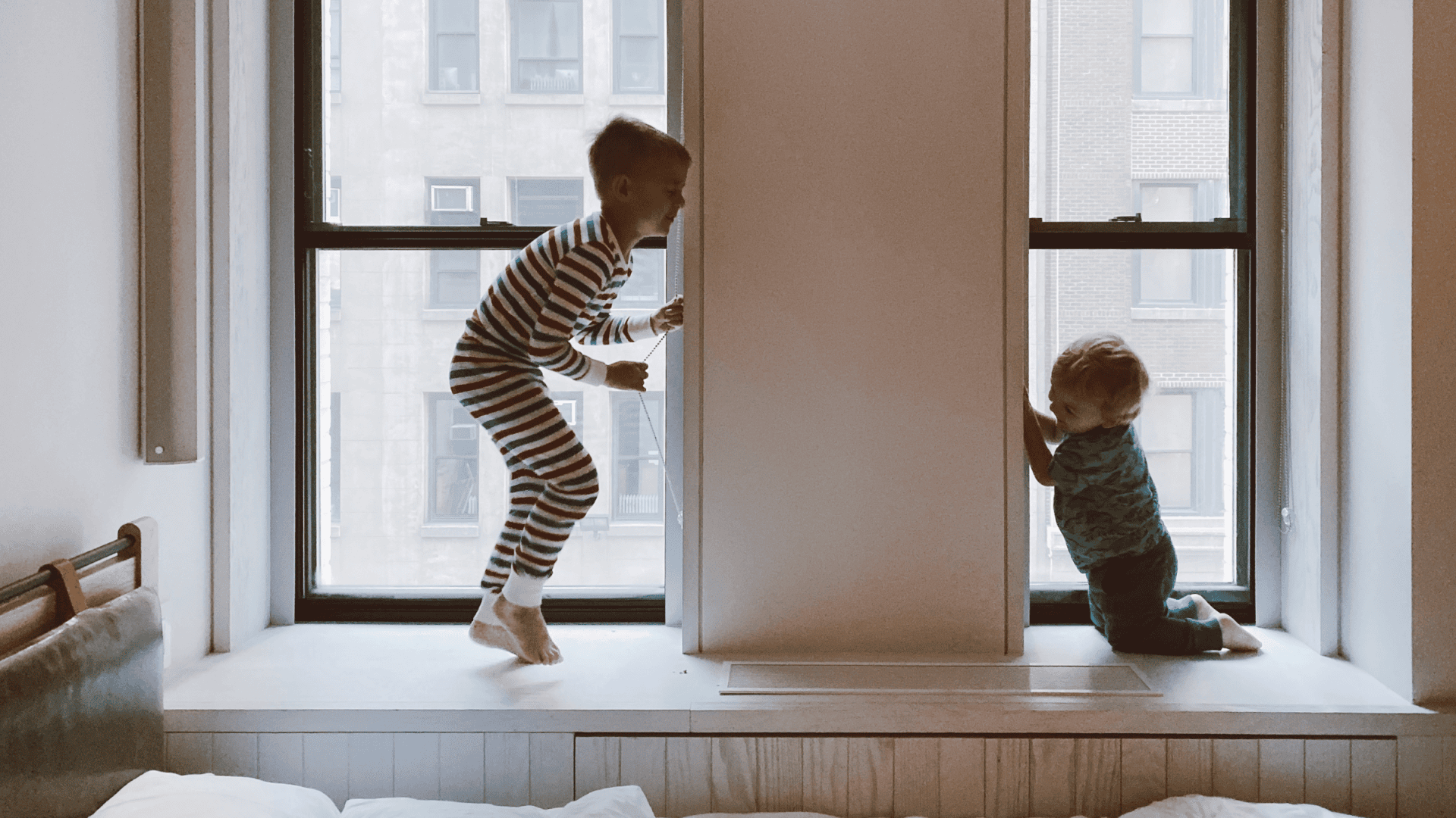 Twee kinderen spelen bij een raam met gelaagd glas (doorvalveilig).