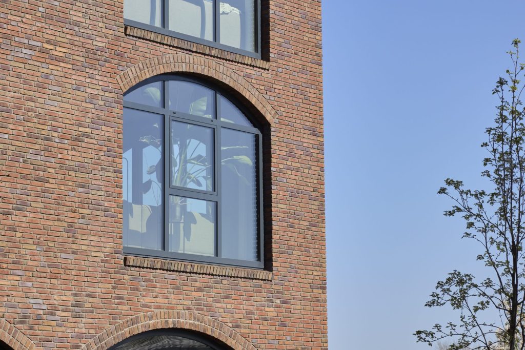 Een bakstenen gebouw met grote ramen van gelaagd glas (letsel en doorvalveilig).