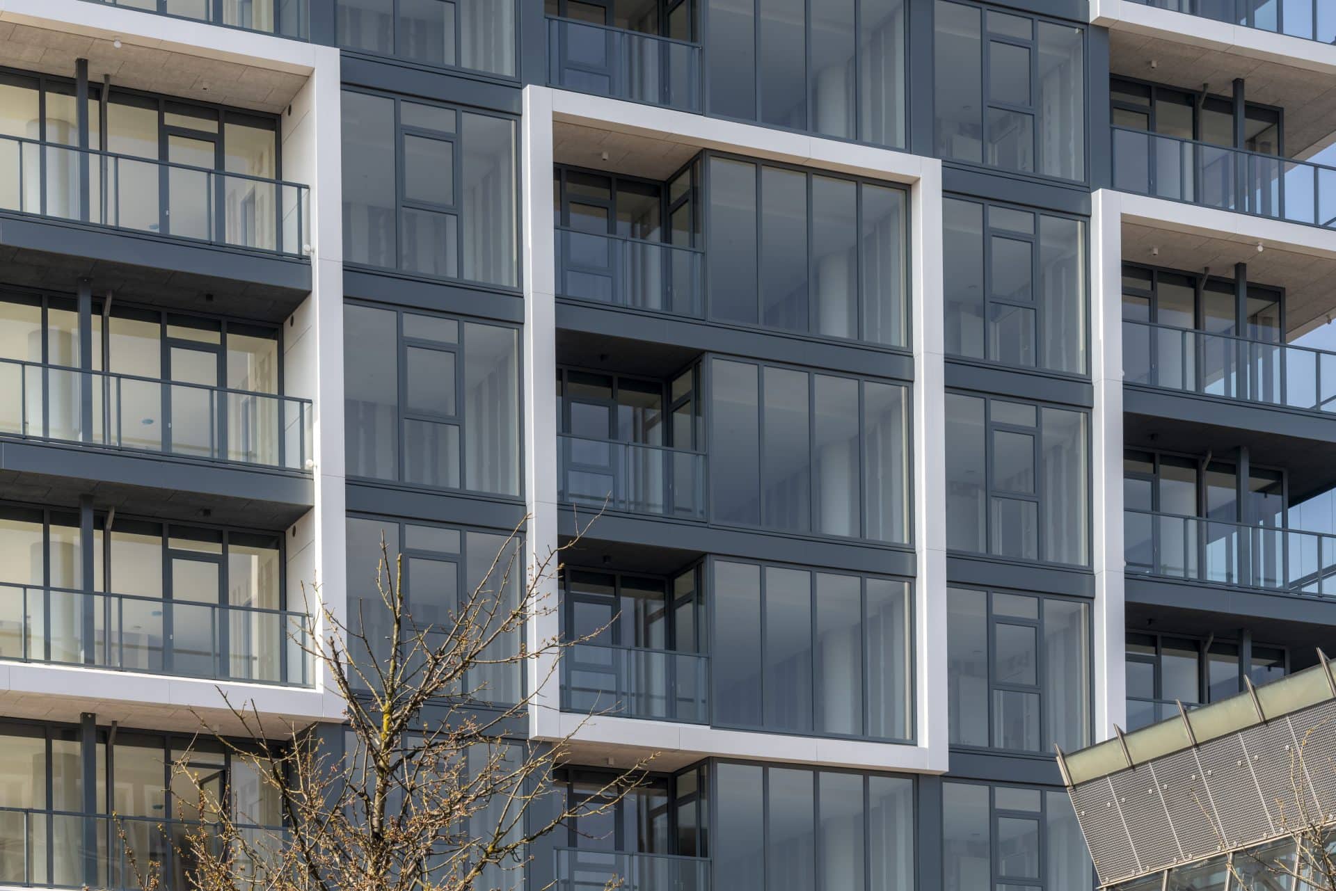 Moderne appartementen met balkons van gehard glas (veiligheid) en grote ramen.