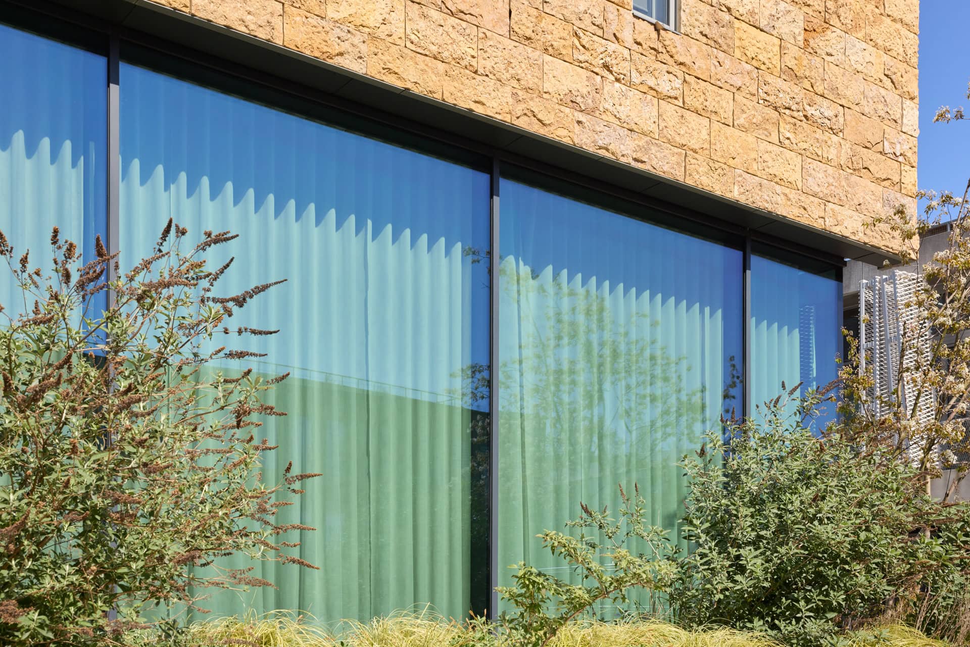 Voorgevel van Edge Stadium Amsterdam met zonwerend glas MOSA Sun 50/22 en vliesgevels langs de Zuidas